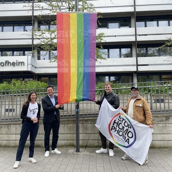 Carmen Weber aus dem Rathaus, Bürgermeister Christian Vogt, Sven Rühl und Hermann von „Colorful e.V. vor der Regenbogenfahne am Rathaus 