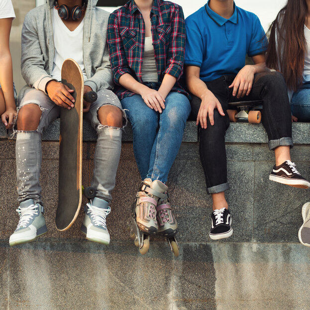 Jugendliche sitzen auf einer Mauer