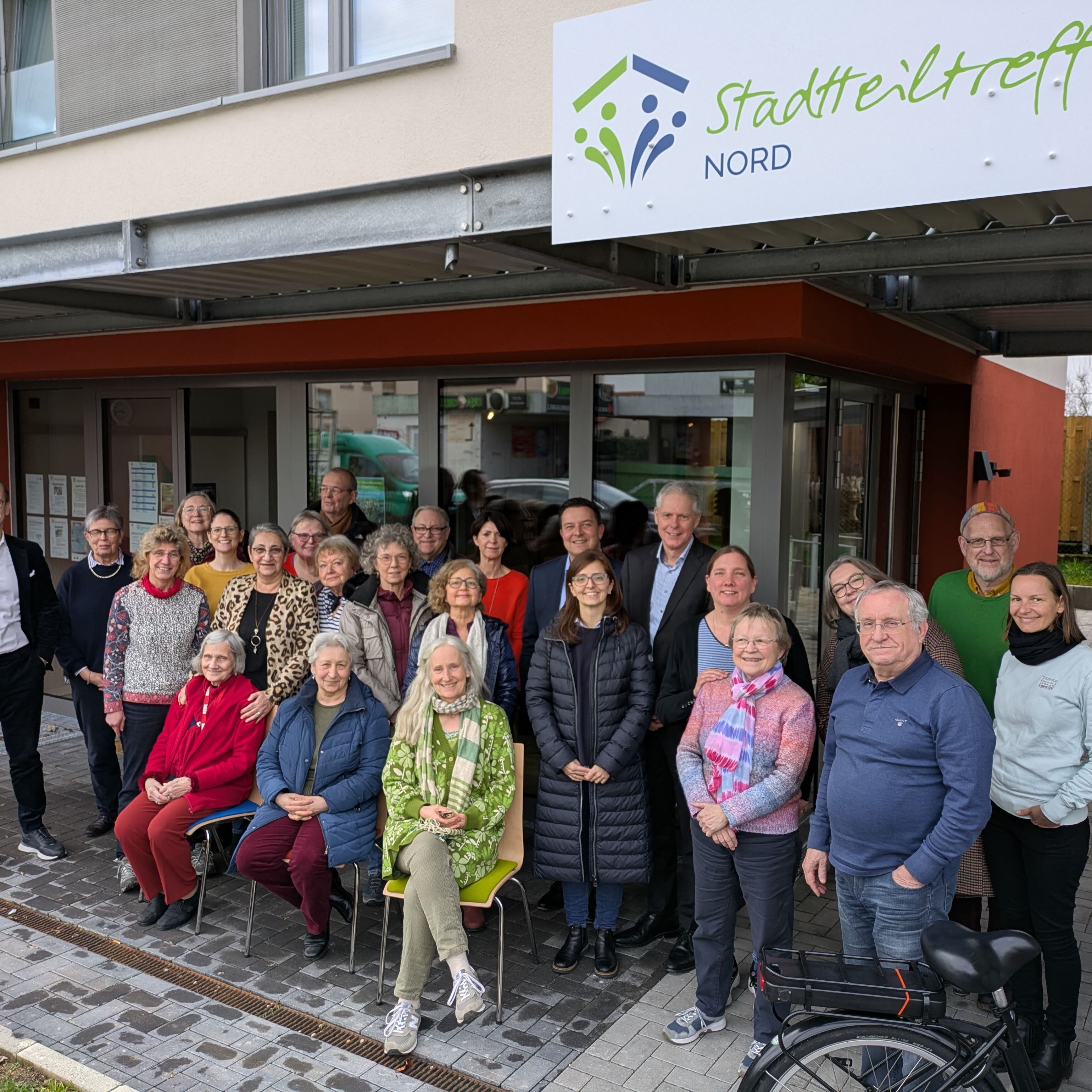 Das Foto zeigt den Vorstand des Caritasverbands Taunus, Ludger Engelhardt-Zühlsdorff (7. von rechts) und Eugenie Riffel (davor), Bürgermeister Vogt (links daneben) und der Vorsitzende der HWB-Geschäftsführung, Norman Diehl (ganz links), sowie Mitarbeiterinnen von Caritas und HWB und die Ehrenamtlichen der Familien Nord und Marxheim